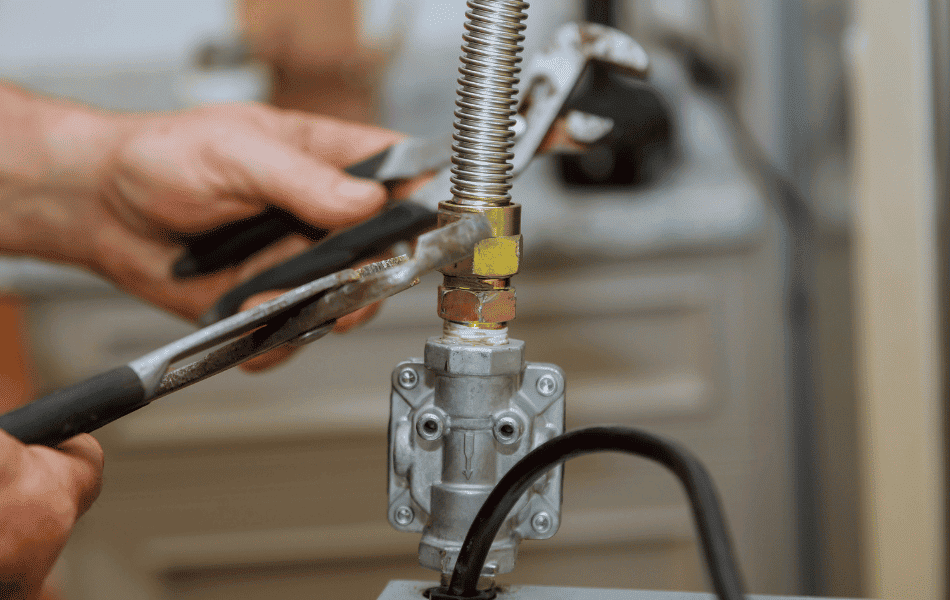 Perth gas plumber installing and tightening a gas valve connection.